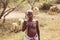 Indian herdsman walking in savanna with his sheeps and goats