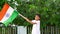Indian Little boy waving Indian flag on green tree background