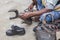 Indian local cobbler repairing shoes beside road by hand using tools in traditional way