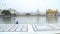 Indian man cleaning pool water in front of the Golden temple in Amritsar.