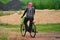 An Indian man on a cycle while on his way to work. He has wrapped up his head to protect himself from the scorching heat in summer