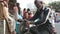 Indian man sharpening knife on a pedaling machine on the street of Mumbai.