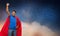 Indian man in superhero cape over night sky