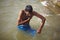 Indian man washing ritual in the river Ganges