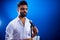 Indian man in white shirt with beard singing in recording studio on blue background