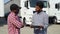 Indian manager and african trucker standing by truck with a clipboard, checking the delivery list
