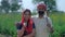 Indian married woman with Duppata on head smiling and standing with husband - Farmer couple