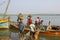 Indian men extract sand in the river way. boat unloading on the background of water