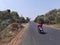 Indian men going on scooter on road in village