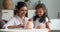 Indian mother and daughter put coins into piggy bank