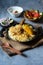 Indian mughlai delicacy chicken biryani in an cooking pan ready to be served .