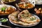 Indian naan bread with herbs and garlic seasoning on plate