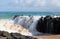 Indian Ocean waves dumping against dark basalt rocks on Ocean Beach Bunbury Western Australia