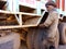 an indian old mechanic pulling out truck tyre for repairing task at automobile workshop in India dec 2019