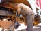 an indian old mechanic putting grease oil into the truck wheel during oiling work at automobile service center in India dec 2019