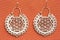 Indian ornamental style earrings on orange background