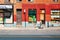 Indian or Pakistani man carrying shopping bags walks on Ontario street with historical buildings and shops in Montreal, Quebec,