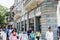 Indian Pedestrians walking pass by the fashion luxury shops in the old British colonial buildings in Mumbai, India