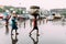 Indian people walking in the rain with carry goods to the train near the area of Howrah Junction railway station