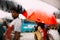 Indian people walking in the rain with umbrella, view through car`s window with rain drops and stream.