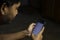 an Indian person is using whatsapp application in smartphone in a dark room with selective focus