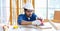 Indian professional bearded male engineer architect foreman labor worker carpenter wears safety helmet and gloves using wood