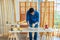 Indian professional bearded male engineer architect foreman labor worker carpenter wears safety helmet and gloves using wood