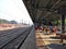 Indian railway station platform and rail line with crowd people waiting for the incoming train arriving