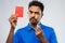 Indian referee with whistle showing red card
