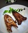 Indian restaurant style fish fry place in white plate and plated beautifully with curry leaves and onions