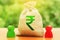 Indian rupee money bag and two businessmen. Business investment, lending, leasing. Dispute solution between . Division of property