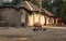 Indian rural village with mud houses ducks and a tribal woman standing in the courtyard.