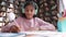 Indian school girl wearing headphones learning online, video call webcam view.