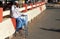 Indian senior physically challenged man seeking help / alms on a busy road.