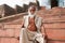 Indian senior sits on the steps of a hindu temple