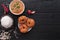 Indian set with spicy lentil donuts, soup and rice on the black wooden table