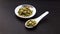 indian spice cardamom in bowl and spoon isolated on black background