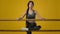 Indian sporty woman flexible girl athlete female dancer ballerina lady in yellow studio with ballet barre stretching