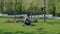 Indian Student with Glasses Reading Abstract Sitting on the Lawn in the Park