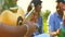 indian students having a lunch in Delhi park outdoors playing on guitar , singing and dancing