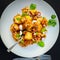 Indian style bread manchurian with capsicum and onion spreaded on it and plated beautifully in white plate with spoons