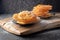 Indian sweets jalebi on a wooden on a dark background. Powdered sugar is poured on top.