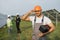 Indian technician in helmet smiling on camera at solar farm