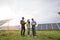 Indian technician standing at solar farm with two inspectors