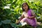 An Indian teenage girl is collecting pumpkin flowers from a rural forest