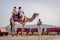 Indian tourists riding camels at Kalo Dungar, Kutch, India.