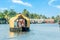 Indian traditional living houseboats floating on Pamba river, with palms at the coastline, Alappuzha, Kerala, South India