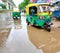 Indian transportation yellow tri wheeler auto rickshaw vehicle in a rainy day in