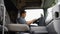Indian trucker sits in his truck and using truck gps navigation