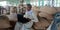 An indian village farmer operating laptop computer system seating upon wheat sacks at farmers market